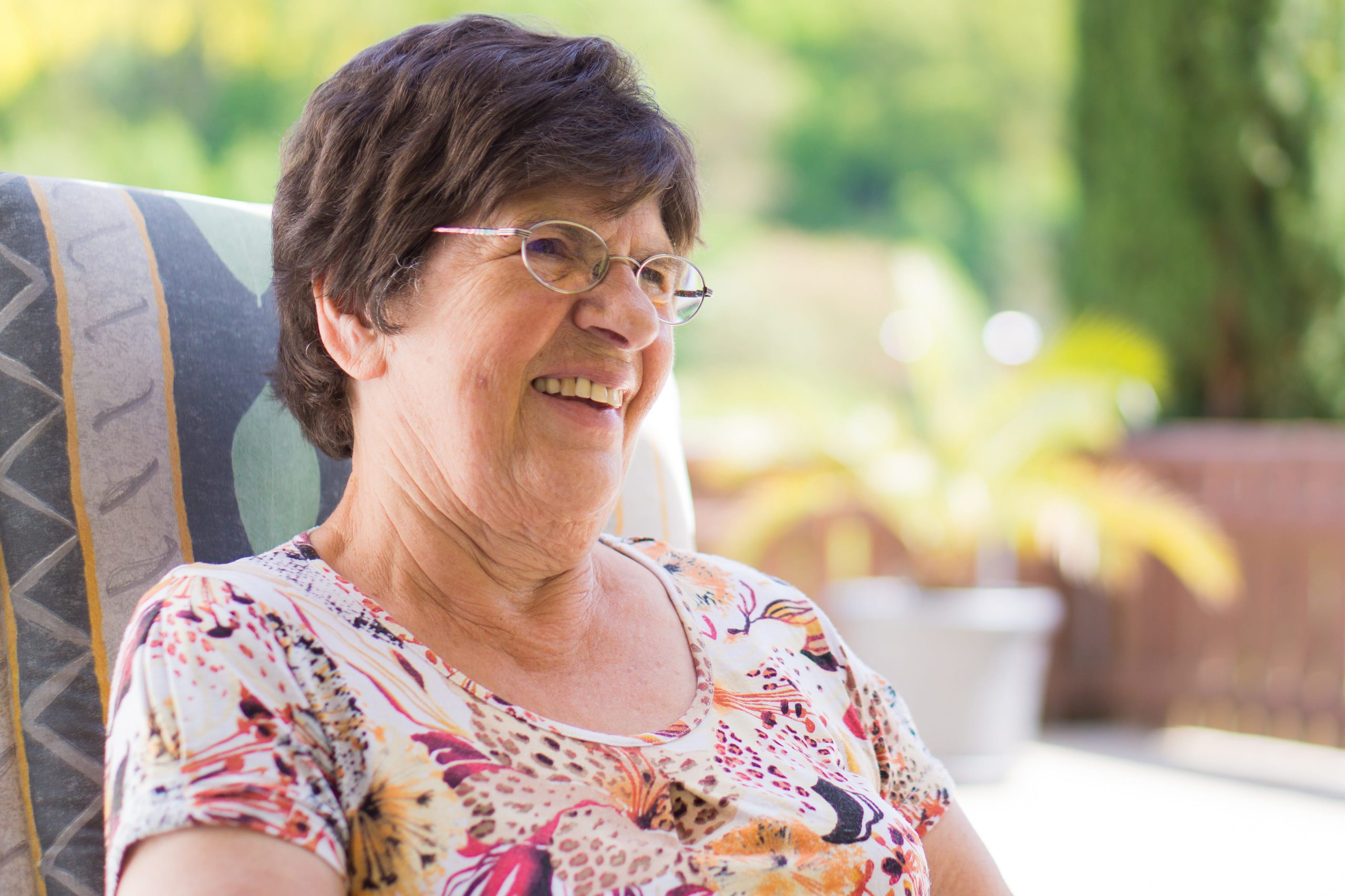 Senior woman sitting outside on patio