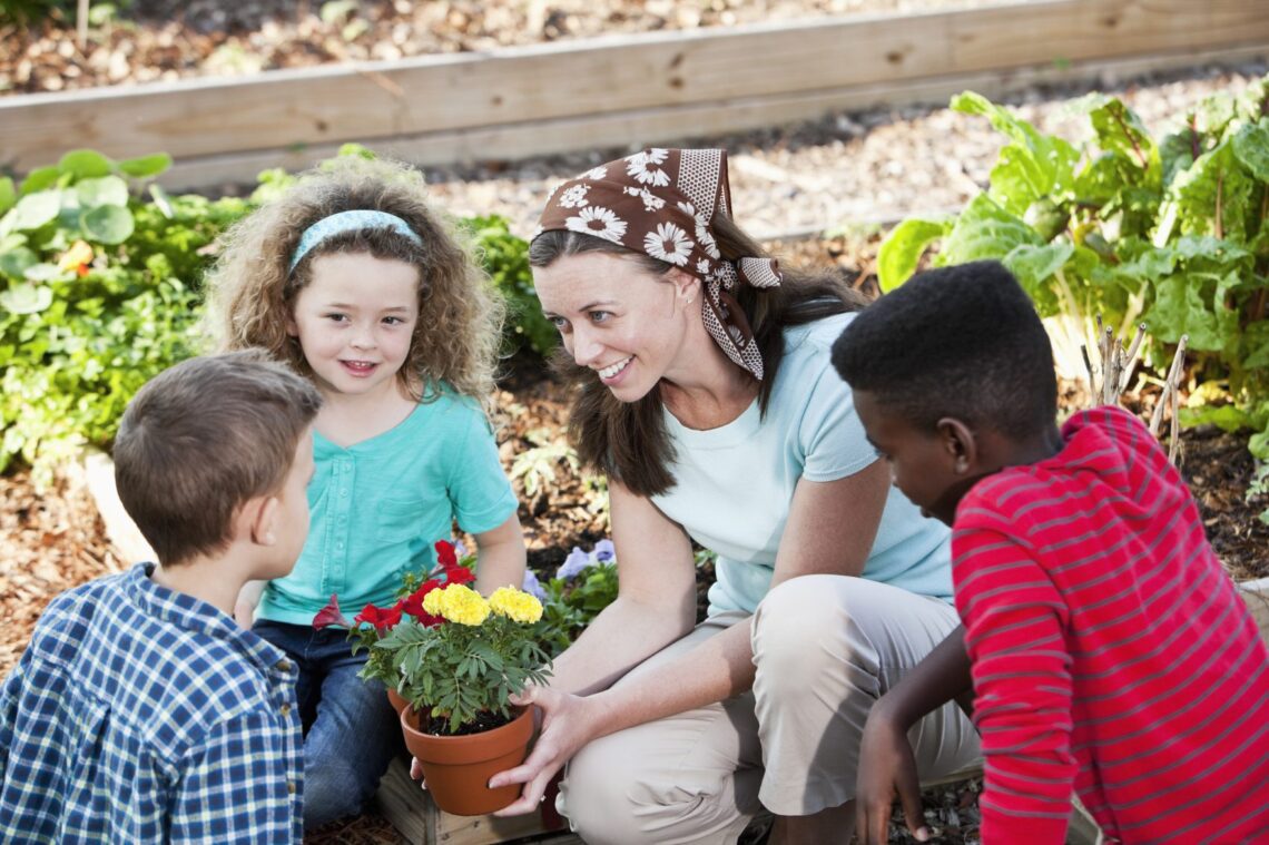 Person showing flower pot to children