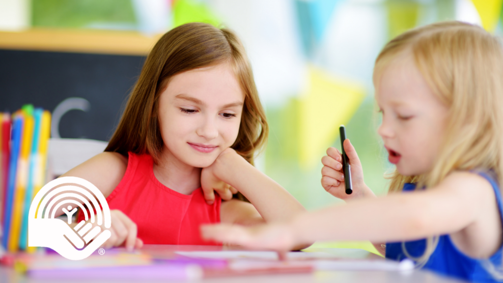 Two little sisters drawing with colorful pencils at a daycare. Creative kids painting together.